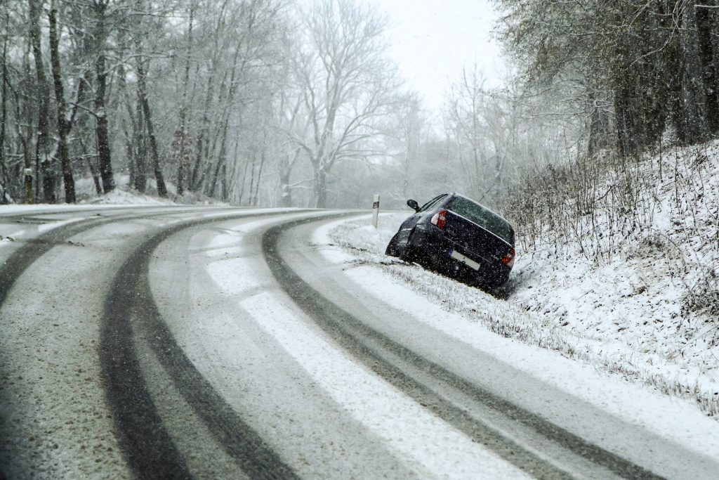 Čierne auto v zasneženom prostredí v priekope.